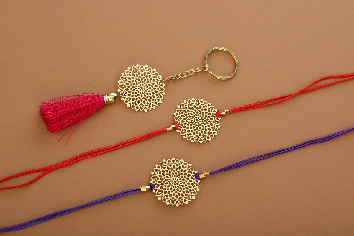 Lotus design Rakhi for bhabhi with red hanging tassel cum keychain ring crafted in brass with golden finish