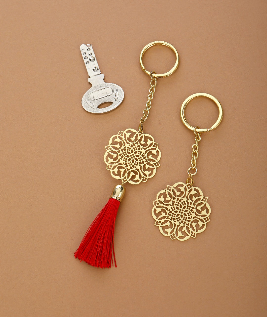 Jaali design Rakhi for bhabi with red hanging tassel cum keychain ring crafted in brass with golden finish