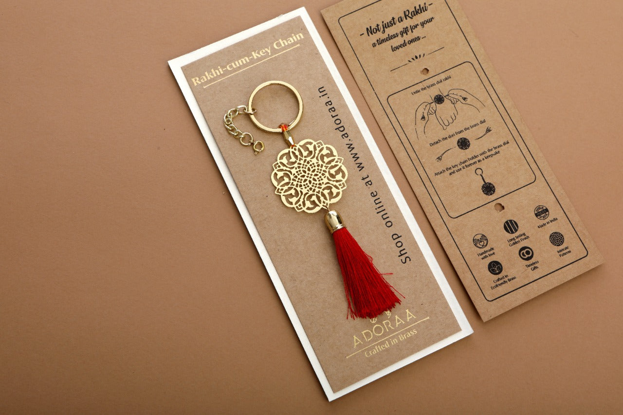 Jaali design Rakhi for bhabi with red hanging tassel cum keychain ring crafted in brass with golden finish