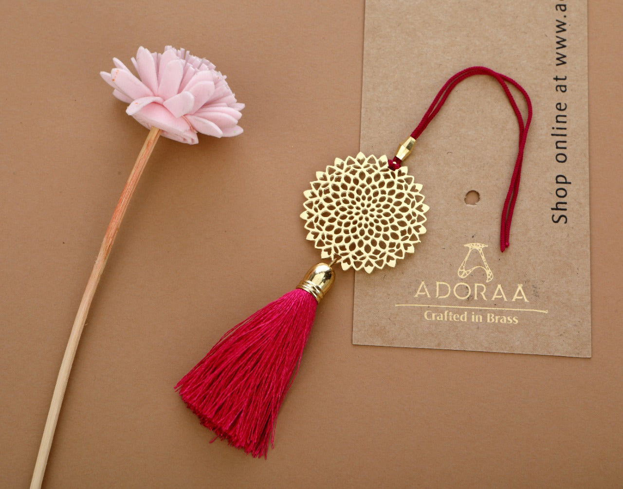 ADORAA's Lotus design Rakhi for bhabi with red hanging tassel cum keychain ring crafted in brass with golden finish